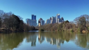 Atlanta Skyline 'ın ön planda Clara meer Gölü ile Piedmont Park' tan 4 km 'lik videosu. Ocak 2022' de güneşli bir günde..