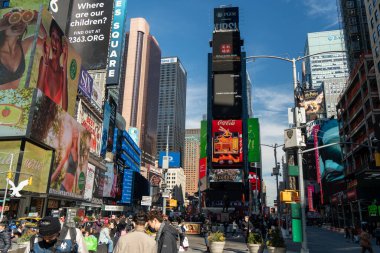 New York, New York: 21 Şubat 2022 - Times Meydanı New York 'un en ünlü simgelerinden biri. Turistler manzaranın ve neon panoların keyfini çıkarıyorlar.