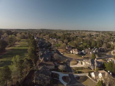 Aerial panoramic view of house cluster in a sub division in Suburbs with golf course in metro Atlanta in Georgia ,USA shot by drone shot during golden hour clipart
