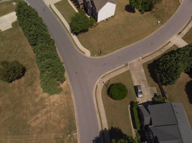 2022 yazının güneşli bir gününde güzel evleri ve manikürlü çimenleri olan panoramik bir banliyö manzarası.