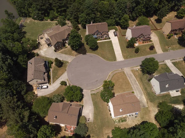 Panoramic aerial view of a suburb with beautiful houses and manicured lawns shot during a sunny day in summer of 2022