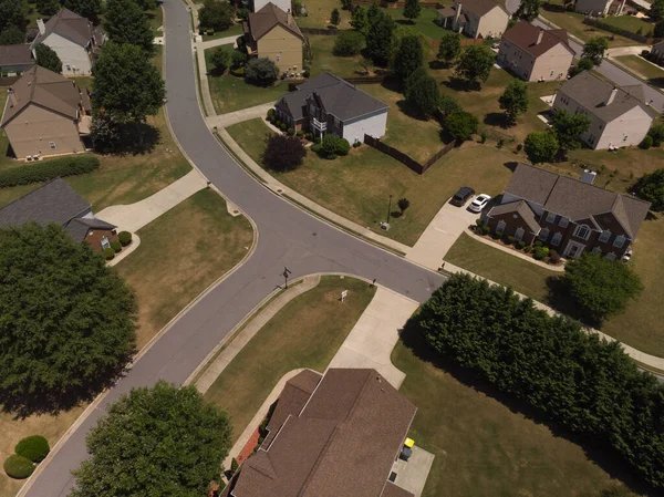 Panoramic aerial view of a suburb with beautiful houses and manicured lawns shot during a sunny day in summer of 2022