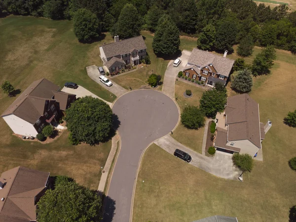 Panoramic aerial view of a suburb with beautiful houses and manicured lawns shot during a sunny day in summer of 2022