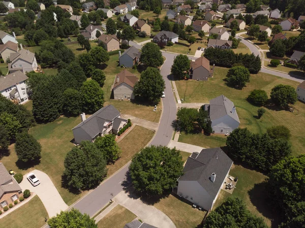 Panoramic aerial view of a suburb with beautiful houses and manicured lawns shot during a sunny day in summer of 2022