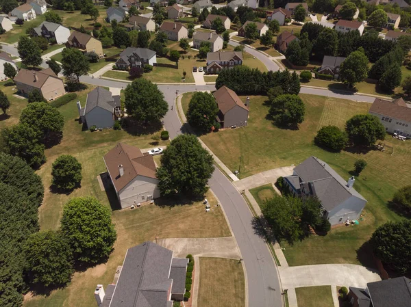 Panoramic aerial view of a suburb with beautiful houses and manicured lawns shot during a sunny day in summer of 2022