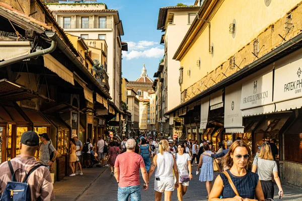 Floransa, İtalya: 29 Ağustos 2022-Panoramik şehir manzarası ve alışverişçiler ünlü Ponte Vecchio köprüsü üzerinden alışveriş yapıyorlar