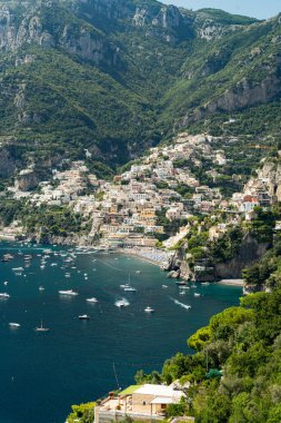 Ünlü Amalfi kıyı şeridinin panoramik manzarası ve turist taşıyan teknelerle dolu dağ.