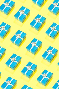 Sarı arka planda mavi bir hediye kutusu Noel, doğum günü ve diğer parti kutlamaları gibi çeşitli amaçlar için..