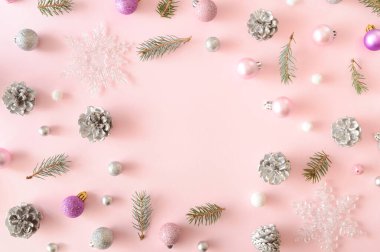 Noel arkaplanı, ortasında yuvarlak çerçeve olan Noel eşyalarından oluşur. Estetik pastel pembe arkaplan.