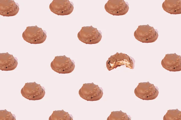 Шоколадне Печиво Розташоване Візерунку Якому Одне Печиво Кусається Рожевому Фоні — стокове фото