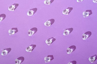 Mor arka planda elmaslar. Estetik sevgililer günü pahalı mücevher hediye konsepti.