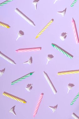 Mor arka planda renkli doğum günü mumları. Doğum günü kutlaması deseni.