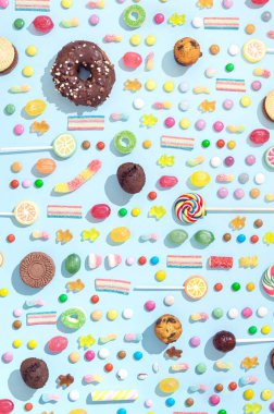 Mavi arka planda farklı şekillerde şekerlemeler var. Şeker şekeri konsepti.