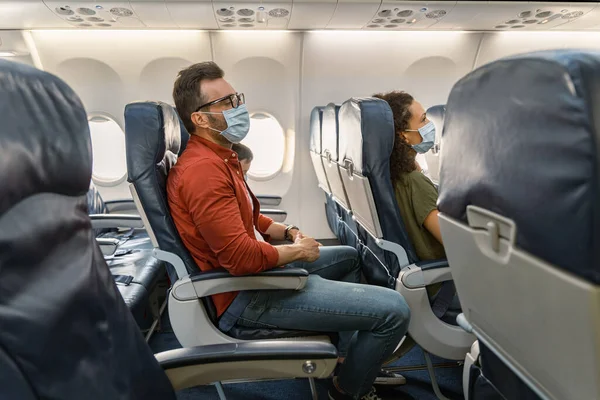 Muž s brýlemi odpočívající v křesle během letu v letadle — Stock fotografie