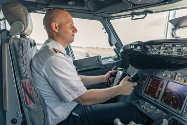 Kokpitte oturan ve direksiyonu tutan kendinden emin pilot.