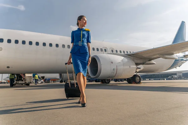 Female flight attendant walking with black suitcase — Stock Photo, Image