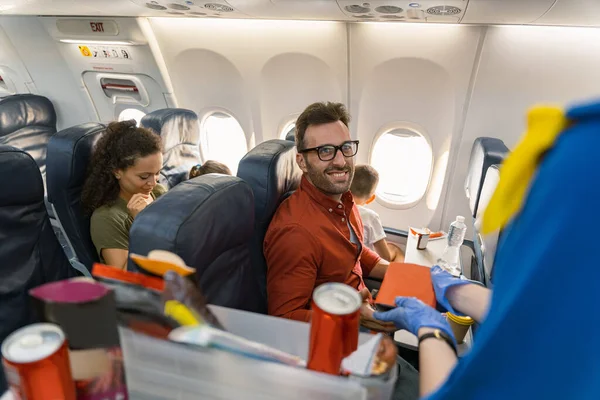 Šťastný muž v brýlích čeká na oběd box na palubě letadla — Stock fotografie