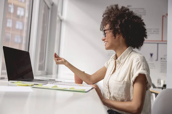 Афроамериканська леді за допомогою ноутбука дивиться лекцію онлайн — стокове фото