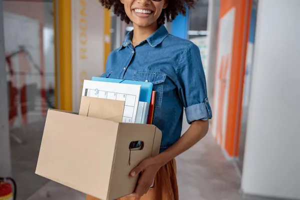 Glückliche hübsche Frau trägt eine Schachtel im Büro — Stockfoto