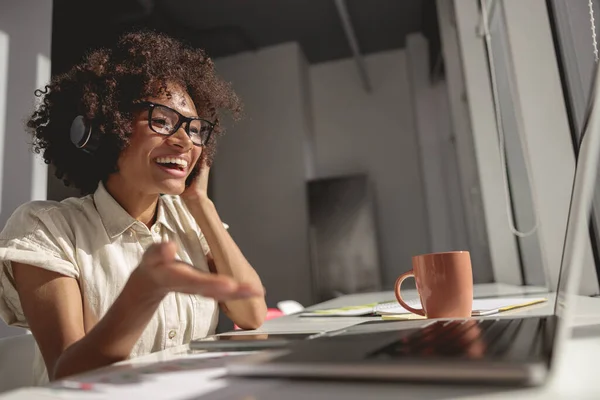 Гарненька молода жінка розмовляє під час відеодзвінка в офісі — стокове фото