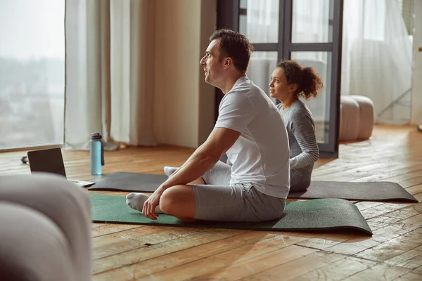 Mann und Frau beim Yoga zu Hause — Stockfoto
