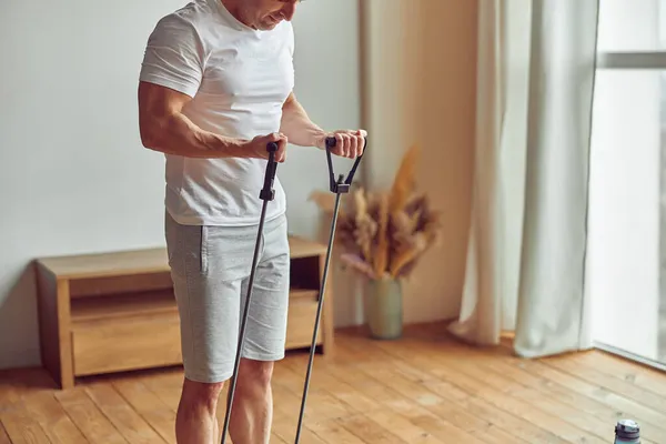 Homme athlétique faisant l'entraînement domestique avec l'équipement — Photo