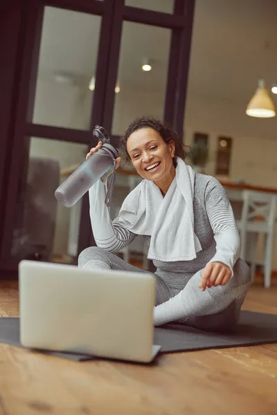 Glückliche junge Frau beim Training mit Laptop drinnen — Stockfoto