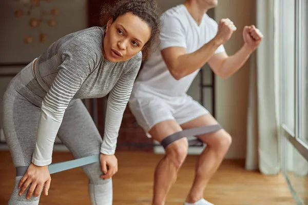Deportiva pareja haciendo poderoso entrenamiento en casa —  Fotos de Stock