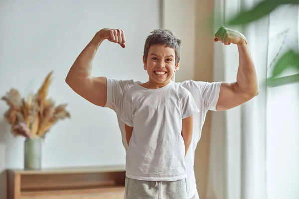 Niño feliz haciendo ejercicio con un padre fuerte —  Fotos de Stock