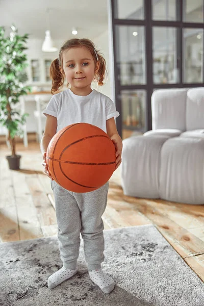 Chica feliz jugando baloncesto en la sala de estar —  Fotos de Stock
