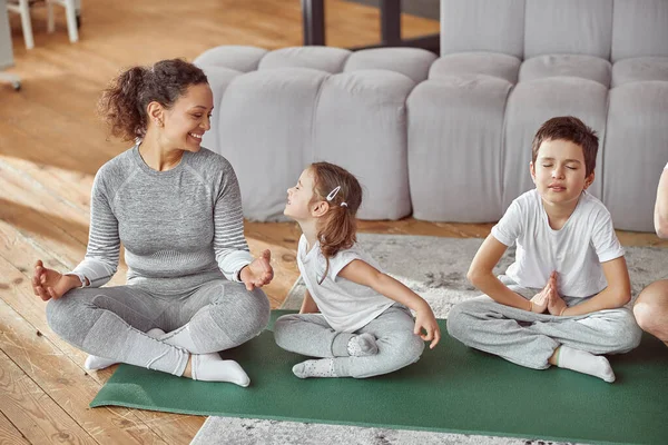 Glückliche Familie praktiziert gemeinsam Yoga zu Hause — Stockfoto