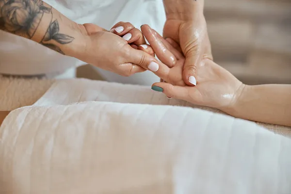 Professionele zelfverzekerde massage meester doet procedures om Kaukasische vrouw in minimalistische moderne kabinet — Stockfoto