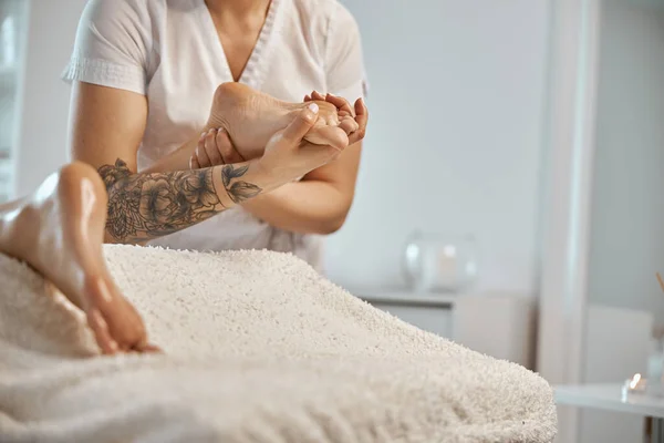 Professionell säker massage mästare gör procedurer för att kaukasiska kvinna i minimalistiska moderna skåp — Stockfoto
