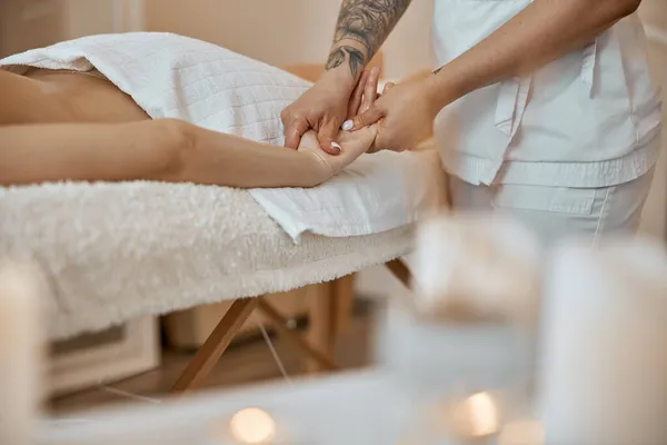 Professionell säker massage mästare gör procedurer för att kaukasiska kvinna i minimalistiska moderna skåp — Stockfoto