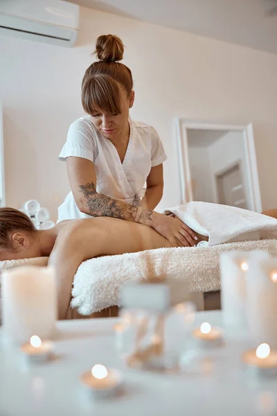 Professionell säker massage mästare gör procedurer för att kaukasiska kvinna i minimalistiska moderna skåp — Stockfoto
