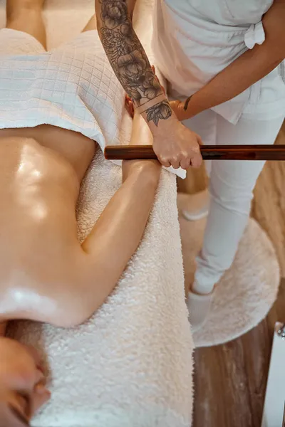 Professionele zelfverzekerde massage meester doet procedures om Kaukasische vrouw in minimalistische moderne kabinet — Stockfoto