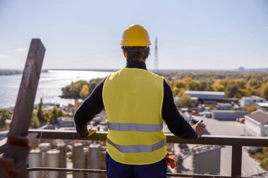 Fabrikada elinde kahve olan bir erkek işçi.