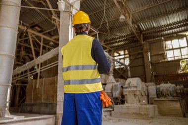 Fabrikadaki depoda duran erkek işçi.