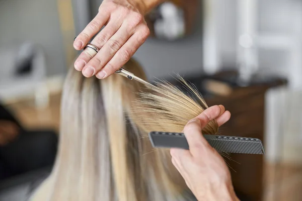 Friseur schneidet Haare einer blonden Frau im Salon — Stockfoto