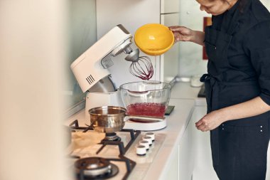 Genç ve güzel melez kadın modern mutfak evinde lokum hazırlıyor.