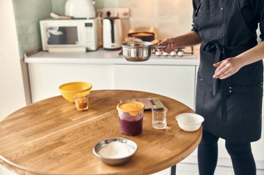 Genç ve güzel melez kadın modern mutfak evinde lokum hazırlıyor.