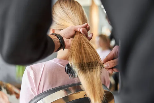 Peluquería Pofessional está peinando un pelo de hermosa mujer rubia caucásica en el salón moderno —  Fotos de Stock