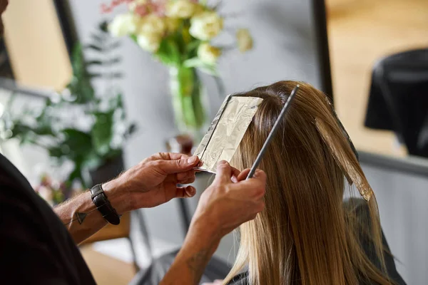 Estilista masculino seguro es teñir el cabello de rubia caucásica cliente femenino —  Fotos de Stock