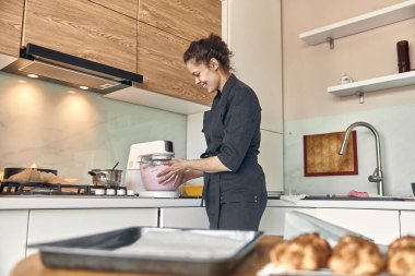 Genç melez kadın evde lokum pişiriyor.