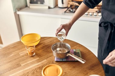 Genç ve güzel melez kadın modern mutfak evinde lokum hazırlıyor.