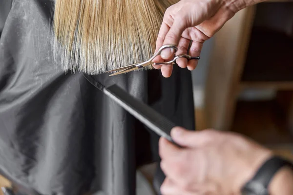 Peluquería está cortando el pelo de la mujer rubia es salón —  Fotos de Stock