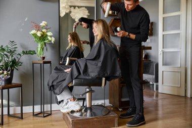 Güzeller güzeli beyaz saçlı güzel kadın güzellik salonunda. Erkek efendi saçlarını kurutuyor.