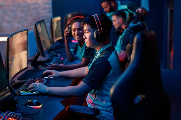Jonge gamers in headsets spelen in video game club — Stockfoto