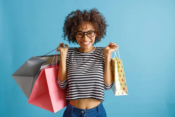Alegre mujer africana sosteniendo coloridas bolsas de compras —  Fotos de Stock