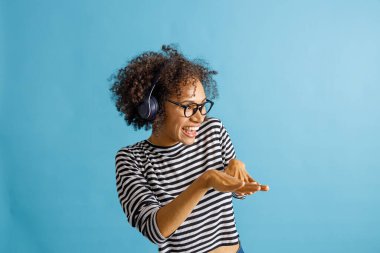 Neşeli kulaklıklı kadın müzik ve danstan hoşlanıyor.